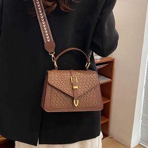 Brown crocodile embossed handbag with wide woven strap and gold buckle detail