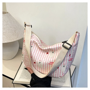 Detail of crescent shoulder bag featuring pink stripes and cute panda cherry prints