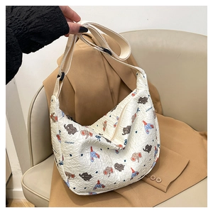 Detail of white tote bag featuring cartoon elephant prints and textured fabric surface