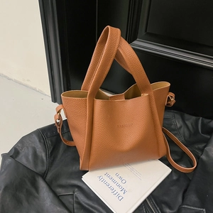 Detail of brown lychee grain leather tote bag with FASHION embossment and gold hardware
