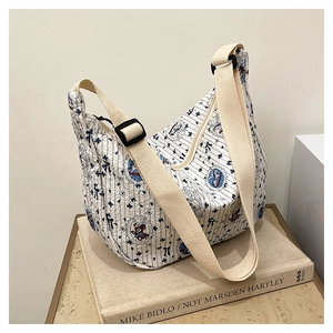 Detailed close-up of quilted hobo bag with blue stripes and cute cartoon bear prints