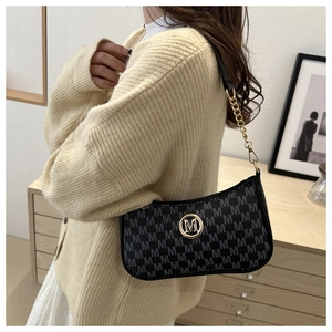 Detail view of vintage black monogram underarm bag with gold M-logo buckle and chain strap