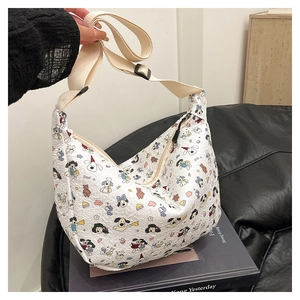 Detail of white Hobo bag featuring cartoon dog print and adjustable fabric shoulder strap