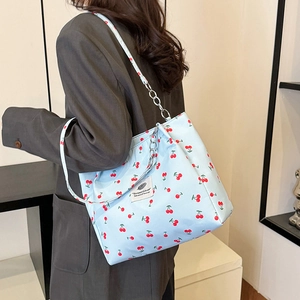 Light blue canvas tote bag with red cherry print and stylish chain shoulder strap