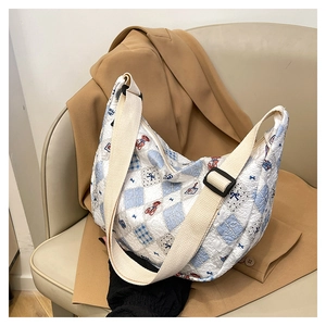 Detail of quilted tank bag with bear and bow patterns and wide canvas strap