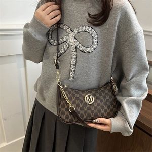 Borsa a tracolla monogramma marrone retrò con logo dorato su felpa grigia e gonna