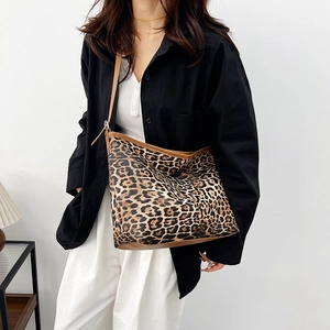 Grand sac cabas à imprimé léopard avec bandoulières marron porté par un mannequin chic
