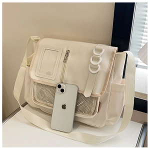 Détail du sac bandoulière en toile crème avec poches en filet et sangle ajustable