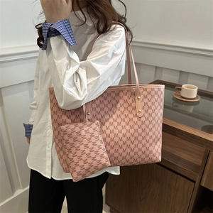 Pink tote bag with letter print and matching pouch shown on a model for casual style