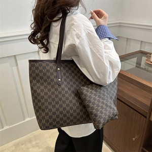 Vintage brown leather tote bag with M-letter print and matching pouch shown on model