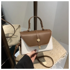 Detail of color-block mini handbag with triangular flap and gold round buckle