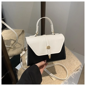 Detail view of contrast color handbag with golden metal buckle and PU leather texture