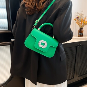 Vibrant green leather crossbody bag with crystal buckle shown on female model