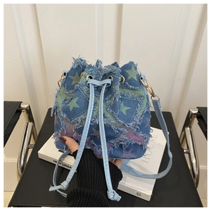Detailed shot of denim bucket bag with frayed star patches and leather drawstring cord