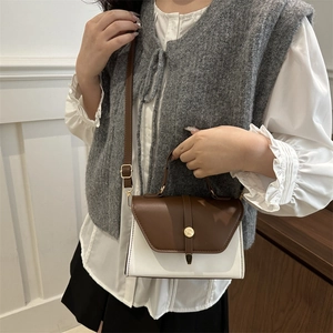 Chic two-tone crossbody bag with brown flap and cream base with golden round buckle