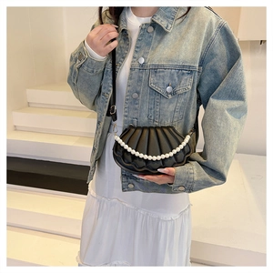 Detail of black shell crossbody bag with large pearl chain handle and pleated PU leather