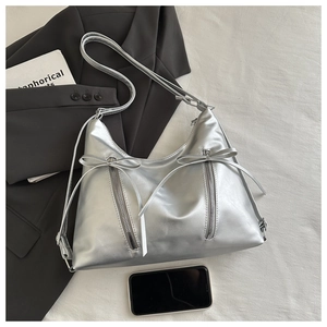 Detail of silver bow backpack with metallic PU texture and functional zippers for women