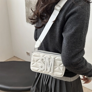 Quilted white camera bag with large SM initials and adjustable wide fabric shoulder strap