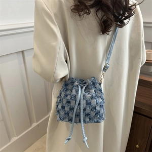 Denim checkerboard bucket bag with fringe trim and drawstring closure for women