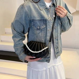 Minimalist black shell-shaped crossbody bag with pearl chain and adjustable strap