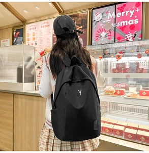 Close-up of black nylon backpack with letter Y print and side pocket for students
