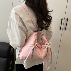 Pink bow shoulder bag with silver zippers and long ribbons for a sweet feminine look