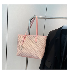 Detail of pink and beige tote bag with M-pattern jacquard and golden hardware pendant