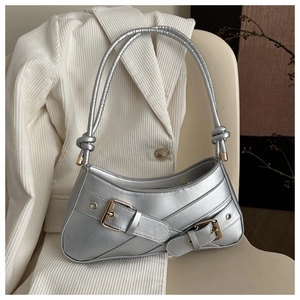 Detail of silver metallic underarm bag with belt buckles and rivet accents