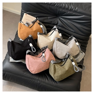Corduroy crossbody bags in six colors with striped straps on a sofa backdrop