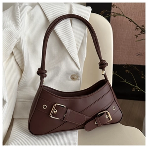 Macro detail of retro dark brown leather bag with golden buckles and knotted strap