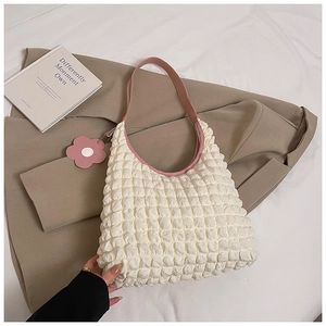 Detailed macro view of white bubble texture fabric with pink leather trim and floral charm