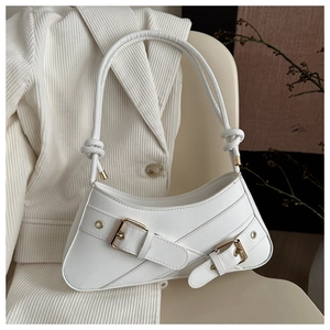 Detail of white baguette bag featuring knotted straps and golden metal buckle hardware
