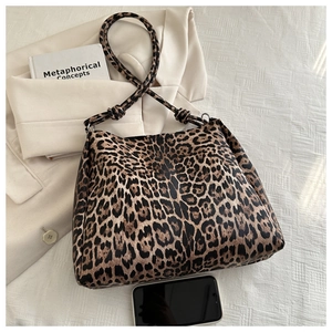 Macro view of leopard print tote bag with stylish knot strap and silver hardware accents