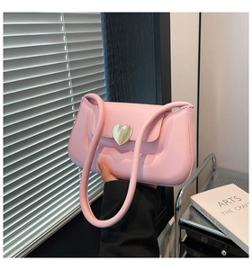 Detailed close-up of a pink matte PU leather shoulder bag with gold heart-shaped metal buckle