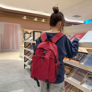 Deep red lightweight nylon backpack with drawstring front pocket for daily commute