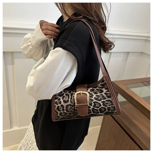 Détail du sac léopard avec bandoulière en cuir marron et boucle dorée élégante
