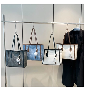 Row of large canvas tote bags in four colors with cute plush charms on a rack
