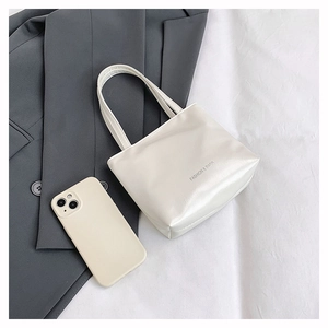 Flat lay di una borsa tote bianca minimalista con logo FASHION & BAGS e accessori urbani