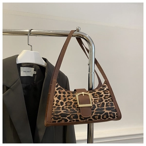 Détail du sac léopard avec boucle dorée et bandoulière en cuir marron