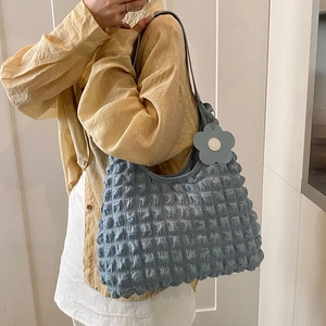 Blue pleated waffle shoulder bag with floral pendant for women in casual street style