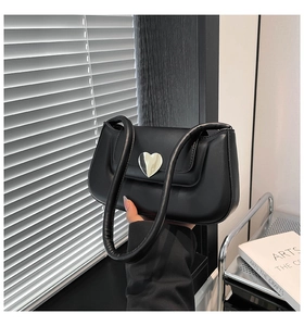 Close-up of black matte faux leather shoulder bag featuring a silver heart-shaped clasp