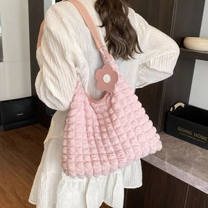 Pink pleated tote bag with 3D bubble texture and floral pendant shown on shoulder