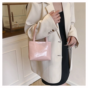 Borsa tote rosa lucida con logo bianco mostrata in un ambiente di vita quotidiana