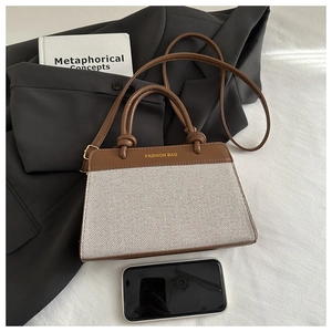 Close-up of canvas and leather tote bag with a smartphone for size reference