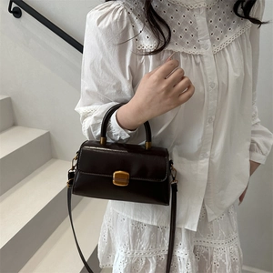 Elegant deep brown leather handbag with gold buckle and top handle for women
