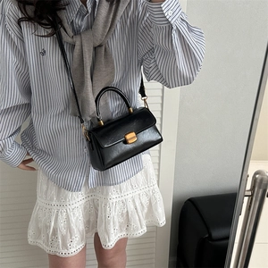 Classic black faux leather crossbody bag with gold buckle and top handle for women