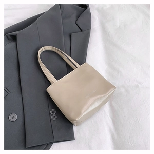 Dettaglio della borsa tote beige con stampa Fashion & Bags su pelle liscia lucida