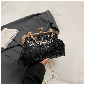Close-up of black sequin evening bag with vintage gold engraved clasp and ring handle