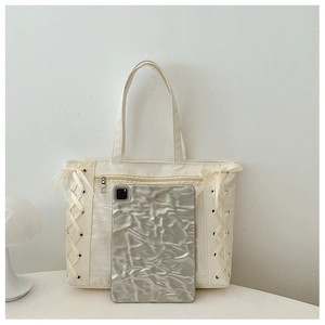 Detail of cream canvas tote bag featuring clear pocket and side ribbon lace-up design