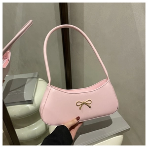 Detail of light pink crescent underarm bag featuring a gold bow metallic buckle